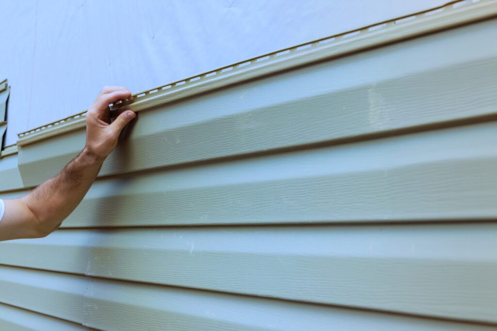 Installation of vinyl siding panels, showing texture and color.