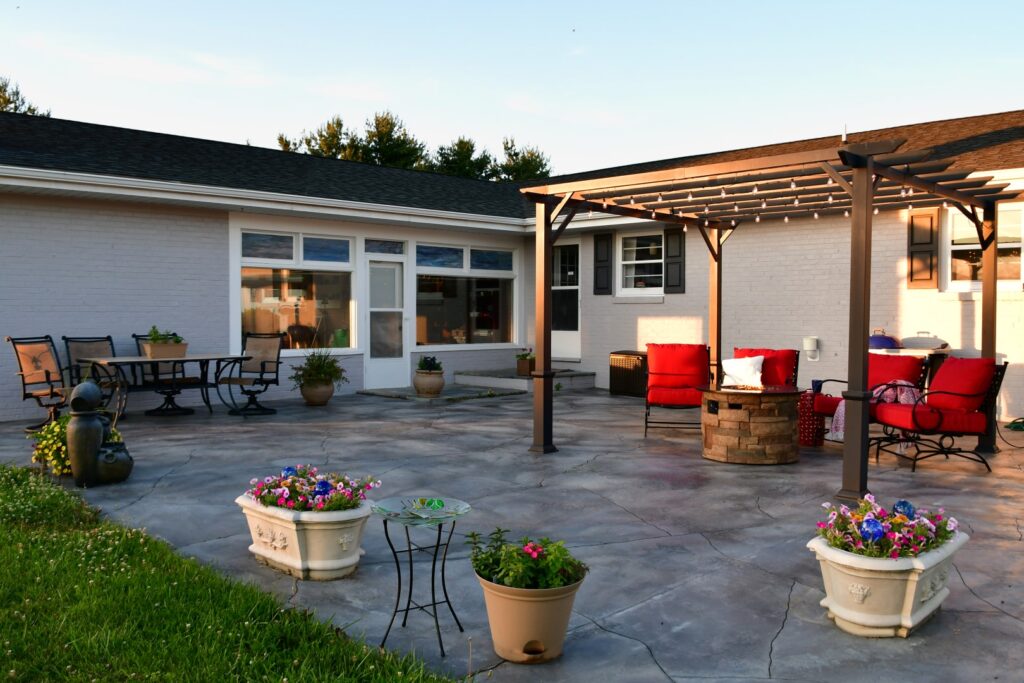 Stamped concrete patio in a backyard with outdoor seating.