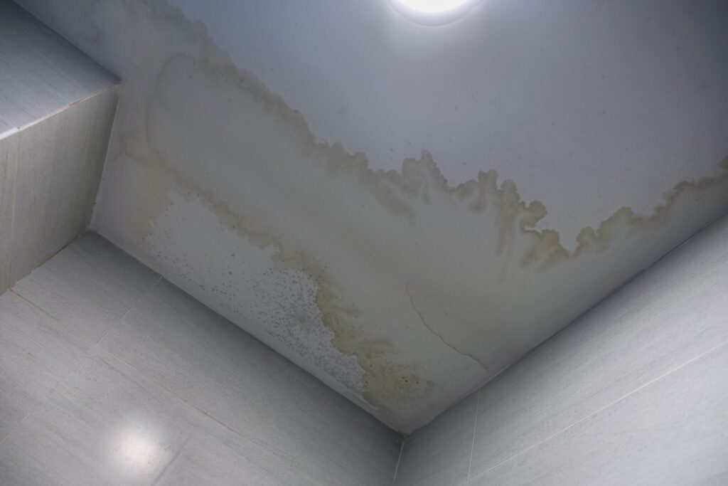 Water damage and stains on the ceiling caused by a roofing leak.
